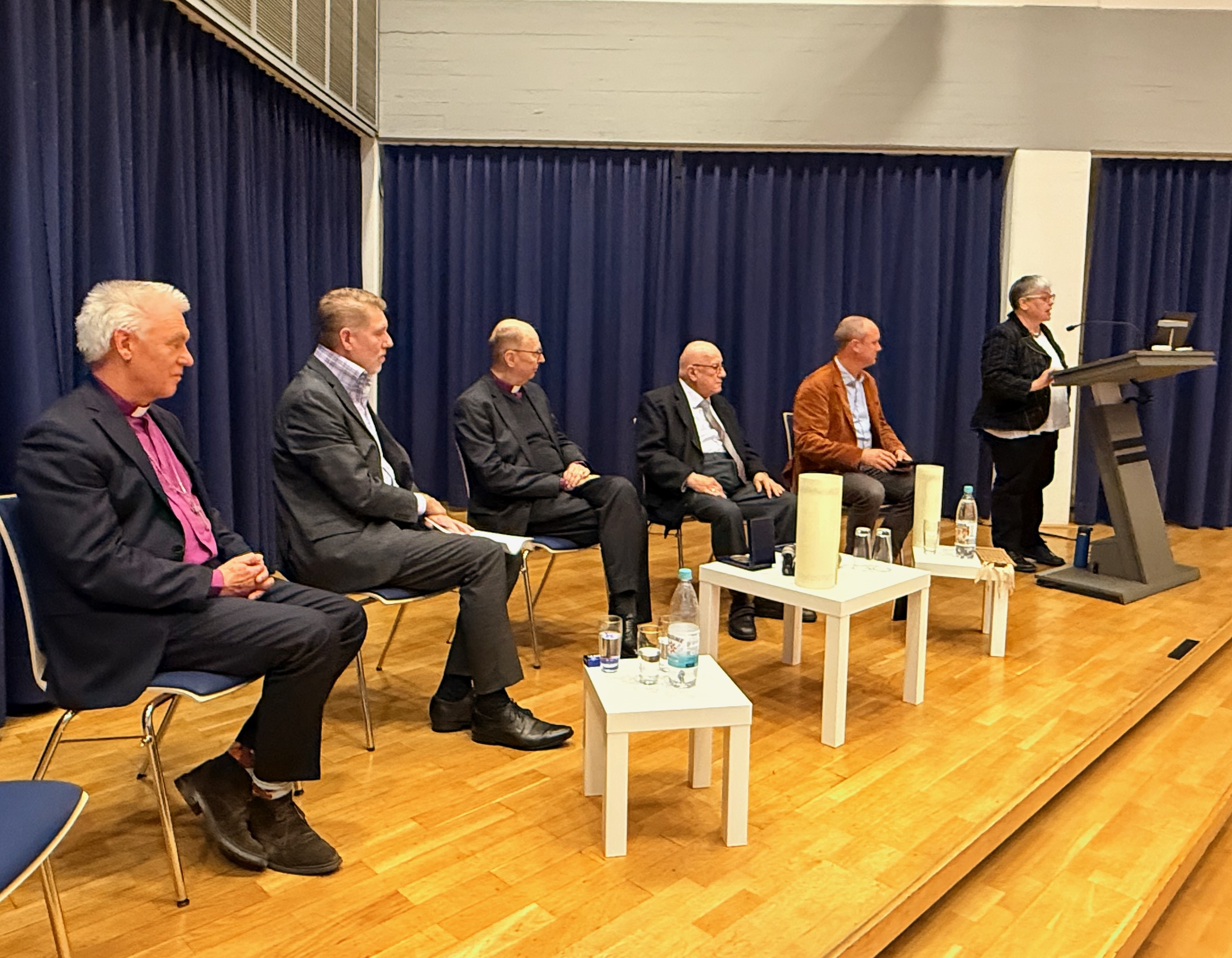 Prof. Angela Berlis am Rednerpultund und die Jury zusammen mit den Preisträgern auf der Bühne.